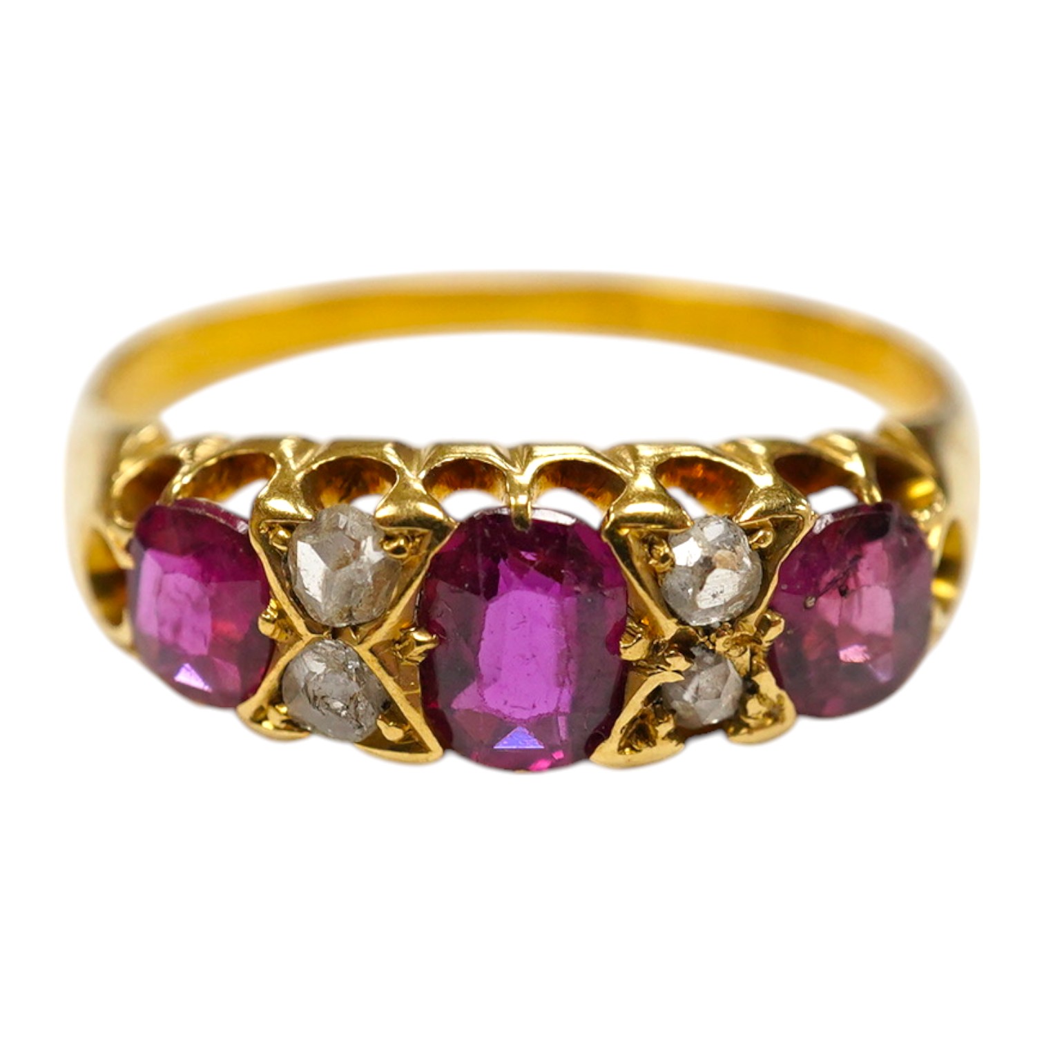 A late Victorian 18ct gold and three stone ruby set half hoop ring, with four stone diamond chip spacers, size P/Q, gross weight 3.2 grams. Condition - poor to fair